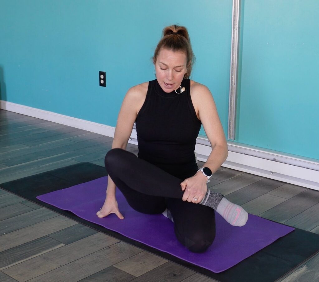 Dr. Chloe demonstrating internal rotation of her right leg while her hip is in flexion